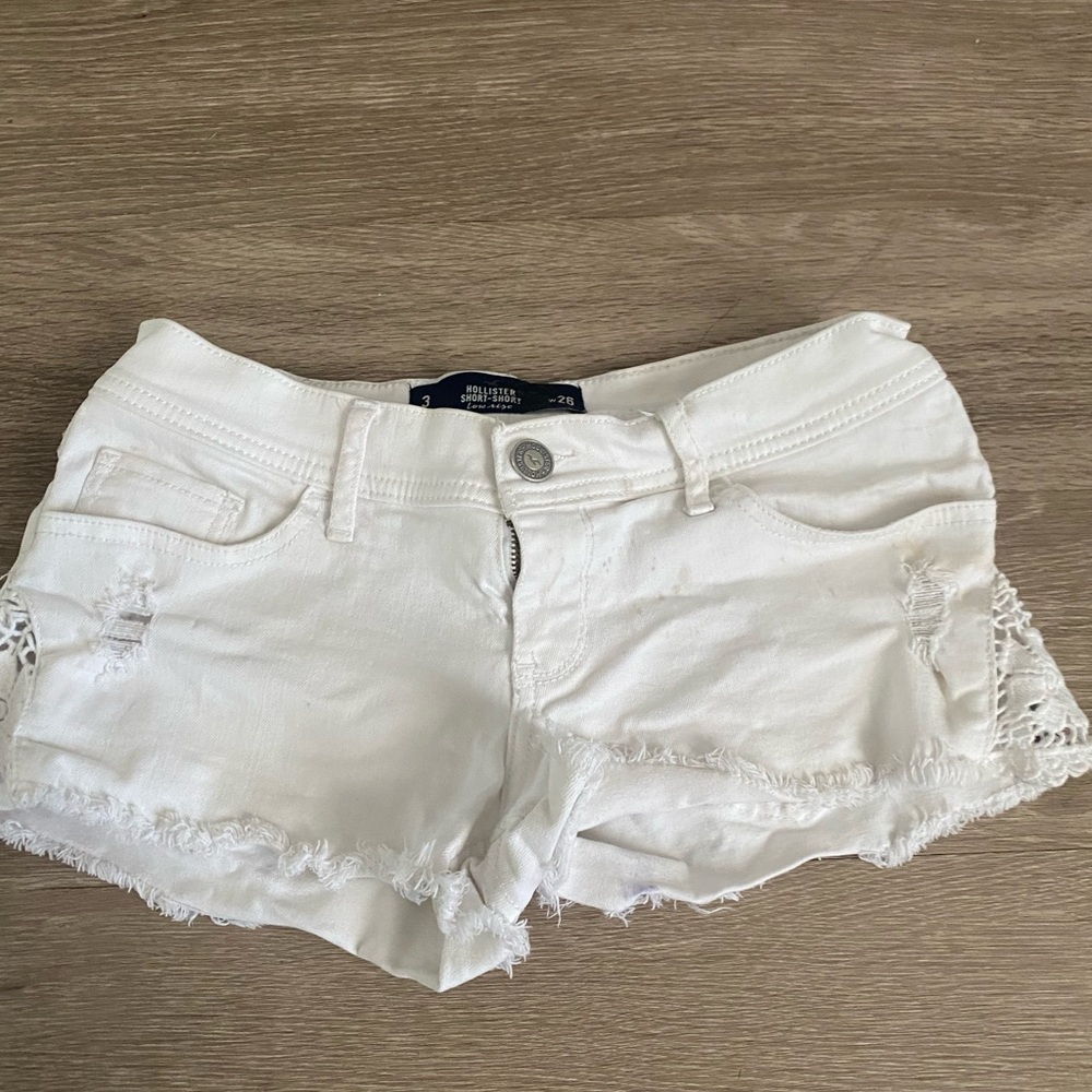 White jean shorts with flower print on the side.